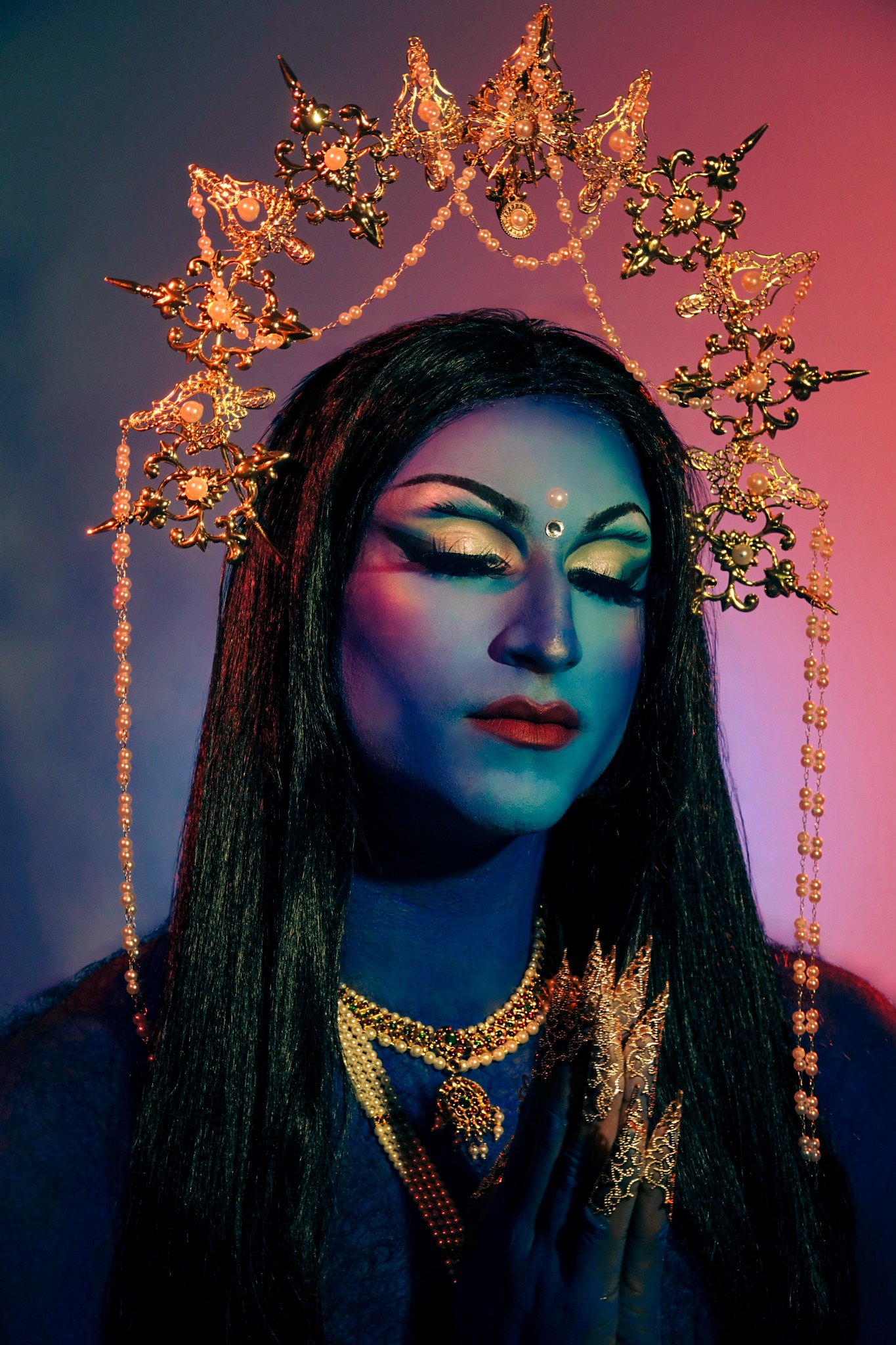 Kalypso portrait with gold crown and blue-toned drag makeup